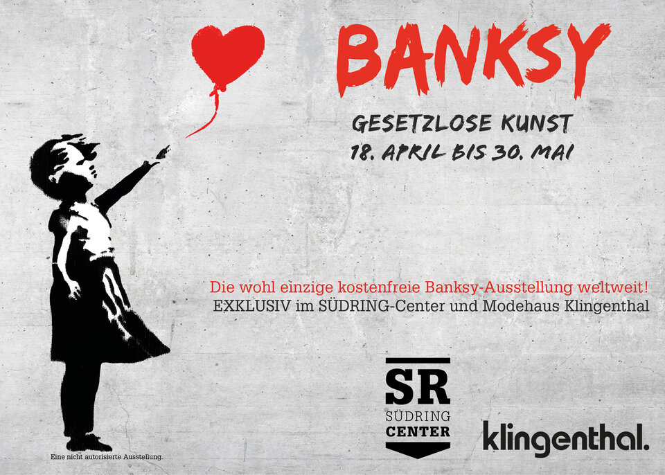 Eine schwarz-weiße Schablone eines Mädchens, das einen roten, herzförmigen Luftballon in der Hand hält, prangt an einer grauen Betonwand, begleitet von einem Text auf Deutsch und Englisch, der für eine Banksy-Ausstellung wirbt.