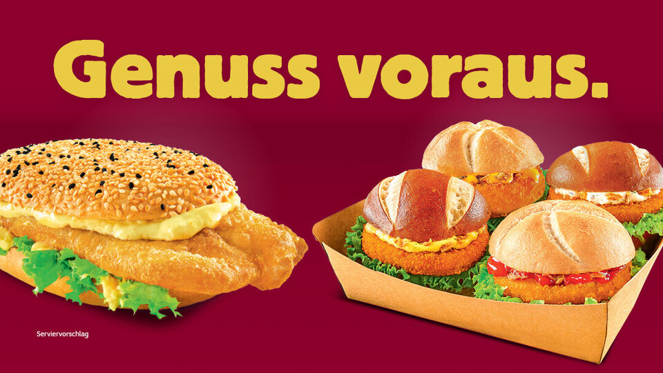 Auf rotem Hintergrund sind ein großes Sandwich mit Sesam und ein kleineres Sandwich mit einem gebratenen Hackfleisch-Patty und Salat abgebildet, dazu der deutsche Schriftzug „Genuss voraus“.